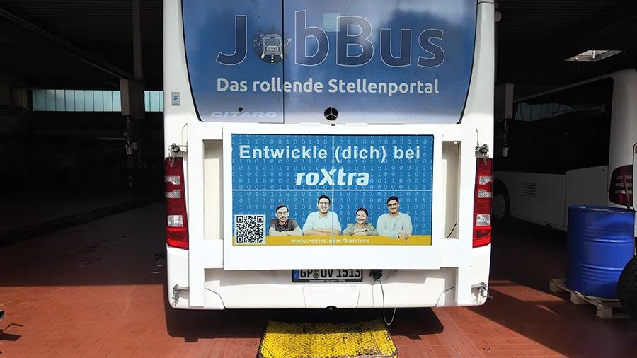 Buswerbung an einem weißen Bus - RoadAds